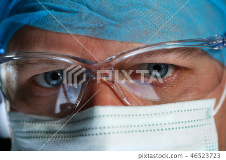 Handsome male physician face wearing protective mask Handsome male physician face wearing protective mask 46523723