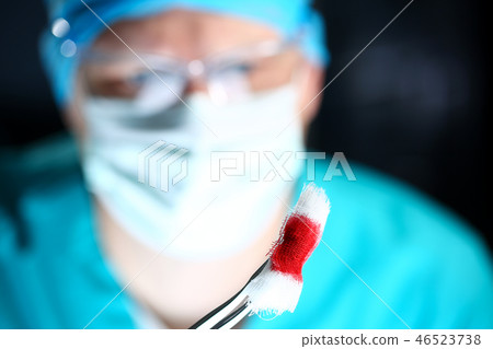 Surgeon in sterile uniform arms holding tools with bio material Surgeon in sterile uniform arms holding tools with bio material 46523738