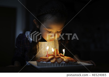 Girl blowing out cake candles Girl blowing out cake candles 46524065