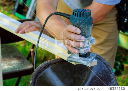 Processing carpenter with Electronic Plunge Router of wooden boards hand cutter close-up Processing carpenter with Electronic Plunge Router of wooden boards hand cutter close-up 46524680