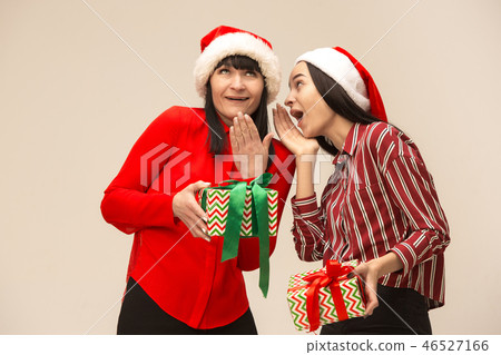 Happy family in Christmas sweater posing on a red background in the studio. 46527166