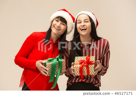 Happy family in Christmas sweater posing on a red background in the studio. Happy family in Christmas sweater posing on a red background in the studio. 46527171
