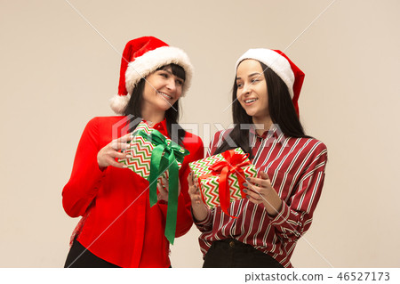Happy family in Christmas sweater posing on a red background in the studio. 46527173