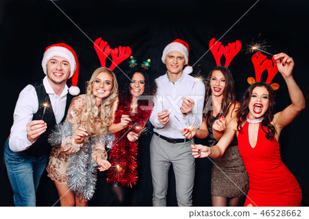 Party with friends. They love Christmas. Group of cheerful young people carrying sparklers and 46528662