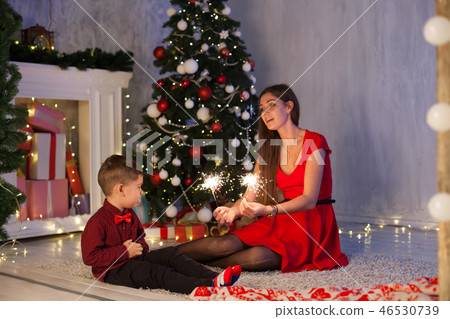 mother and son celebrate the new year at a Christmas tree with gifts Garland lights 46530739