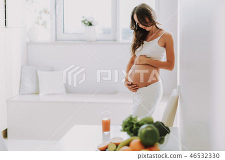 Excited glad woman holding hands on stomach Excited glad woman holding hands on stomach 46532330