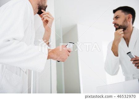 Close up of the man touching beard before shaving it Close up of the man touching beard before shaving it 46532970