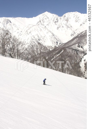 Snowboarder who skis off ski slopes of Hakuba-mura, Nagano Pref. With clear backdrop of Northern Alps Hakuba Mt. Snowboarder who skis off ski slopes of Hakuba-mura, Nagano Pref. With clear backdrop of Northern Alps Hakuba Mt. 46532987