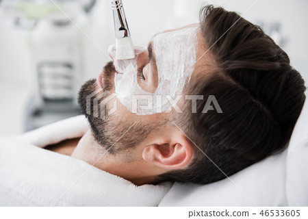 Close up of mans face with white clay mask on it Close up of mans face with white clay mask on it 46533605