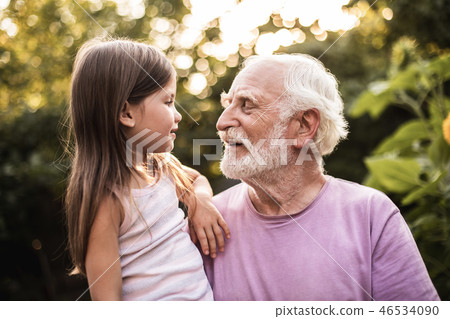 Granddaughter talking with her grandfather in park 46534090