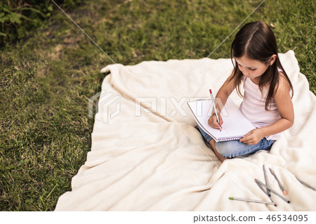 Leisure of preteen girl drawing something in park 46534095