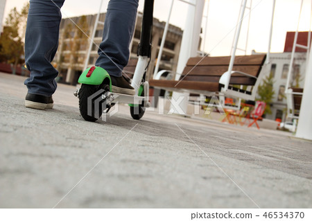 Close up image of a man on an electric scooter. 46534370
