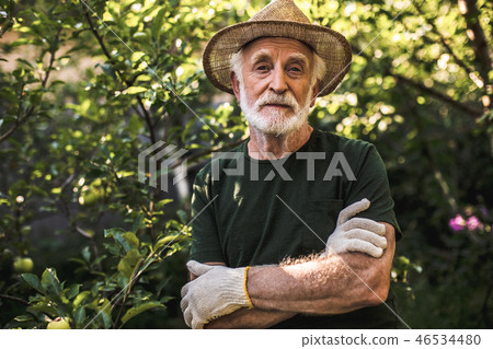Elderly farmer posing on countryside park background 46534480