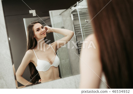 Cheerful young female admiring reflection in apartment 46534932