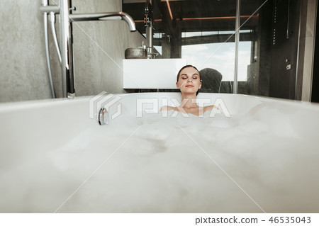 Young smiling lady taking relaxing bubble bath 46535043
