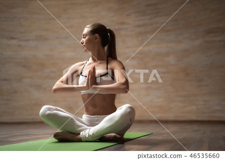 Peaceful lady sitting with hands near the chest and meditating alone Peaceful lady sitting with hands near the chest and meditating alone 46535660