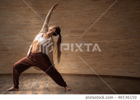 Calm lady putting one arm up while practicing chi gong alone 46536150