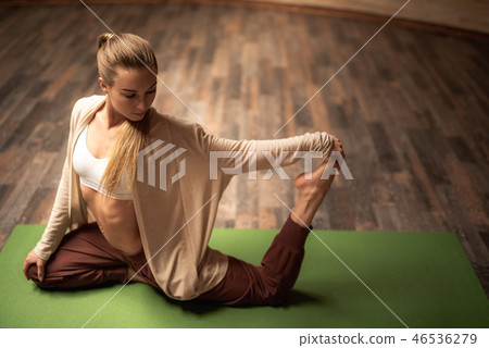 Peaceful lady putting her head down while touching her foot Peaceful lady putting her head down while touching her foot 46536279