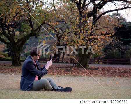 A man taking pictures of the Autumn scenery 46536281