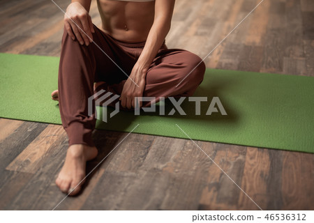 Close up of the legs of young woman sitting on the yoga mat 46536312