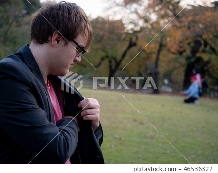 A man taking something out of his jacket pocket 46536322