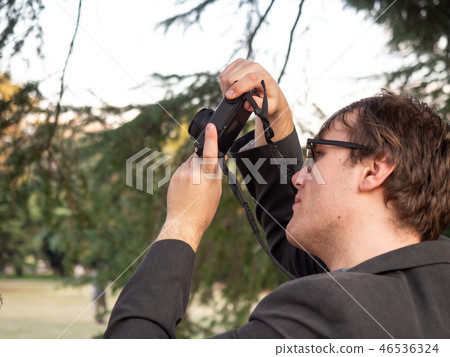 A man taking pictures in the park 46536324