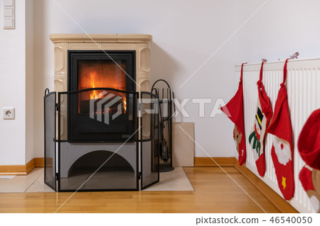 Tiled stove with fire burning inside Tiled stove with fire burning inside 46540050
