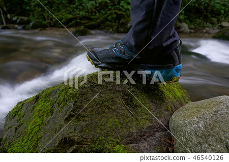 Hiking shoes, close up hiker outdoors walking crossing river, creek 46540126