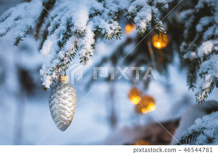 Close-up of a Christmas toy on a snow-covered lively tree in the winter forest on the background of Close-up of a Christmas toy on a snow-covered lively tree in the winter forest on the background of 46544781