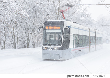 Tram goes along the street during snowstorm Tram goes along the street during snowstorm 46548210