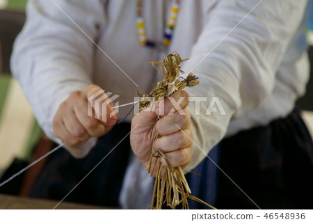 An elderly woman makes a toy for child 46548936