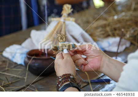An elderly woman weaves an orthodox cross 46548938