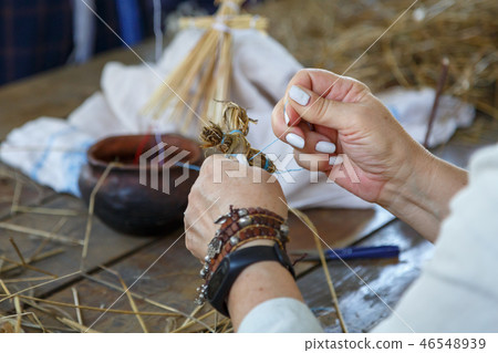An elderly woman weaves an orthodox cross 46548939