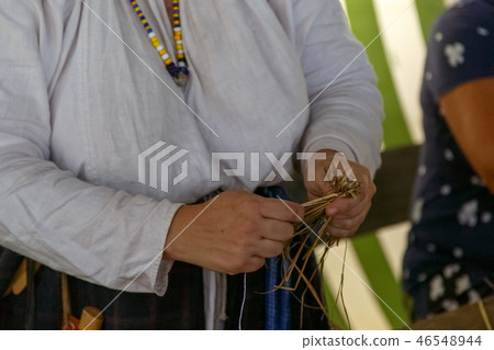Woman makes toy for children from straw Woman makes toy for children from straw 46548944