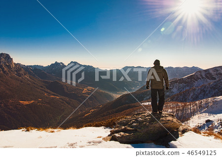 man from behind on the top of a snowy mountain man from behind on the top of a snowy mountain 46549125