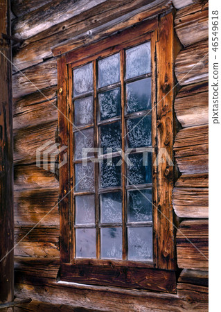 window in the log wall of an old building 46549618