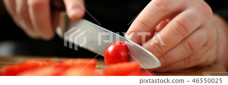 Cook holds knife in hand and cuts on Cook holds knife in hand and cuts on 46550025
