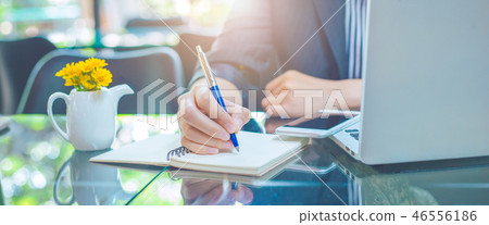 Business woman writing on a notebook.with a pen Business woman writing on a notebook.with a pen 46556186