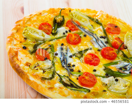 Pizza with sprat, artichokes, cheese, dried tomatoes on unleavened dough 46556581