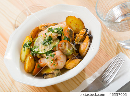 Tasty warm salad with fried potatoes, shrimp and mussels, served at plate Tasty warm salad with fried potatoes, shrimp and mussels, served at plate 46557003