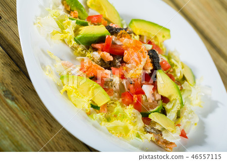 Salad of grilled salmon, avocado, lettuce, tomatoes 46557115