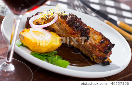 Зork ribs baked under mustard sauce served at plate with spiced sauce Зork ribs baked under mustard sauce served at plate with spiced sauce 46557366