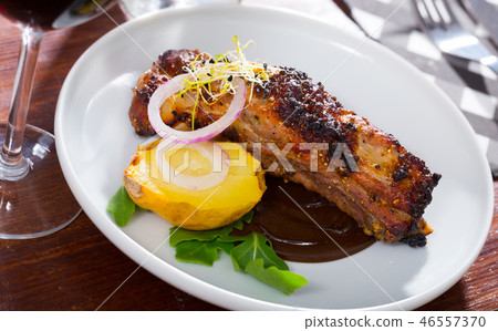 Broiled pork ribs in chocolate sauce with baked potato Broiled pork ribs in chocolate sauce with baked potato 46557370