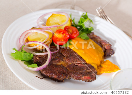 Well-cooked beef steak with cheese and baked potatoes served at plate Well-cooked beef steak with cheese and baked potatoes served at plate 46557382