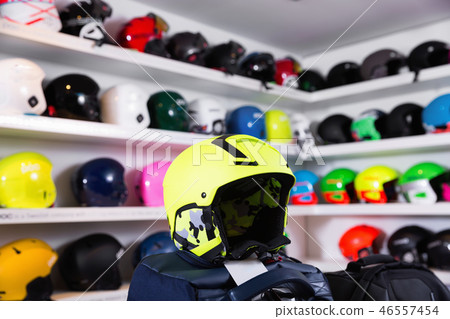 Yellow skiing helmet on background with colorful ski headwear on shelves Yellow skiing helmet on background with colorful ski headwear on shelves 46557454