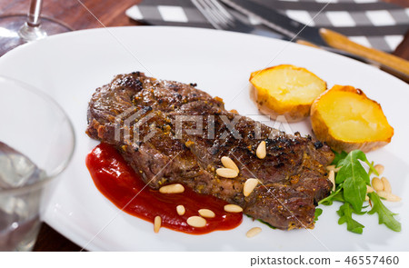Beef steak with ketchup and pine nuts, served with potatoe Beef steak with ketchup and pine nuts, served with potatoe 46557460