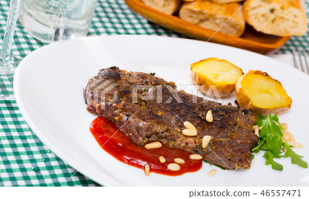 Prepared beef steak with tomatoe ketchup and pine nuts 46557471