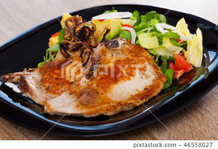 Frying pork loin at plate with salad from avocado, tomatoes and corn salad 46558027