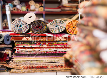 Carpets of different colours in stack at carpet store Carpets of different colours in stack at carpet store 46558353