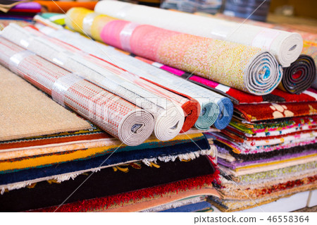 Stack of multicolored quality rugs at carpet shop Stack of multicolored quality rugs at carpet shop 46558364